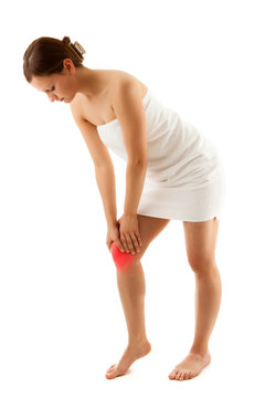 Woman massaging pain knee on white background