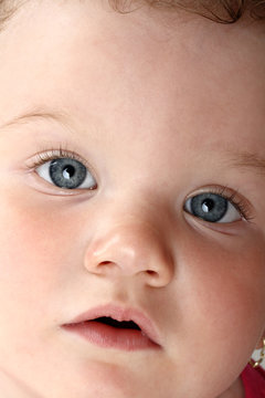 Detailed portrait of puzzled baby girl looking at camera