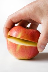 Sliced red apple with human hand over white
