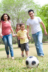 Family  playing soccer and having fun