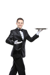 A young butler carrying a tray isolated on white background