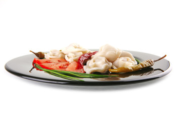 dumplings served with vegetables on black