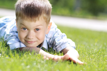 5 years old child lying on the grass.