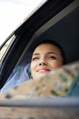 Happy bride in a wedding car