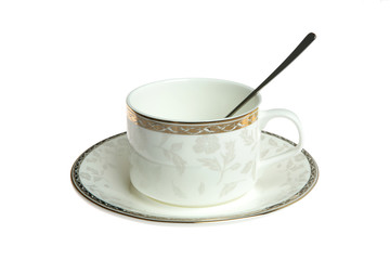 White cup on saucer with spoon isolated on white background