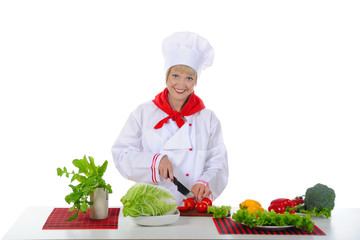 young girl cuts the tomatoes in the kitchen.