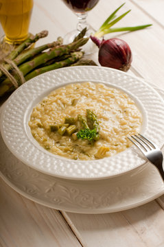 asparagus rice with fork on dish and red wine