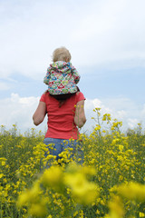 Fototapeta premium mother with child on a yellow field