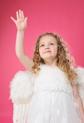 Beautiful little angel girl isolated on pink background