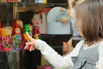 fillette devant la vitrine d'un magasin de jouets