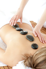 Cute woman having a stone therapy against a white background