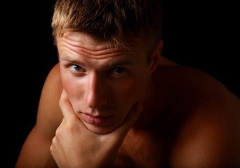 Obraz premium Shadowy dark close-up portrait of young good looking male model