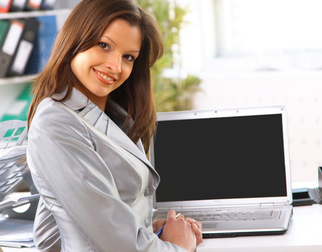 Young business woman showing blank laptop