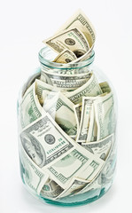 Many 100 US dollars bank notes in a glass jar