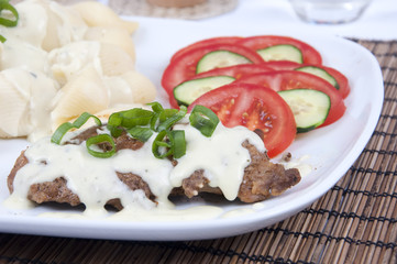 Tasty meat with cheese sauce, pastry and vegetable