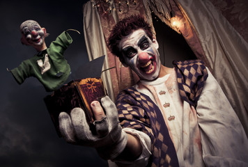 photo of a scary clown holding a Jack-in-the-box toy