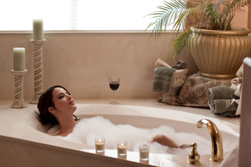 Young pretty lady relaxing in a bubble bath - obrazy, fototapety, plakaty