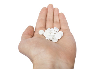 Pile of the white pills on the doctor`s palm isolated on white