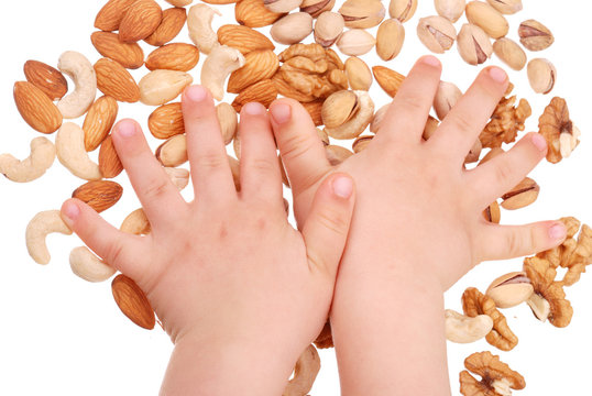 The children's hand holds nuts