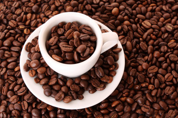 Small white cup of coffee with coffee grain on grain background
