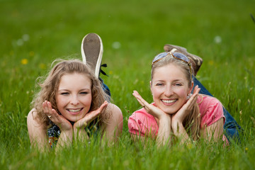 Two sisters lay on the grass