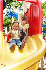 Fototapeta na wymiar Children on slide outdoor in park.