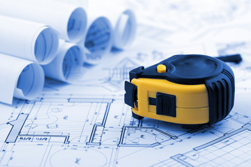 rolls of architectural house plans, tape measure