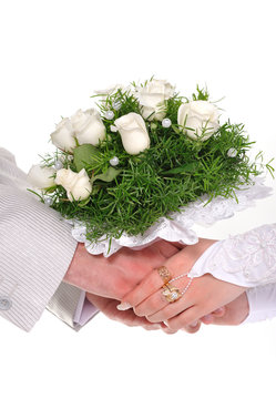 Bride and groom hands with bouquet