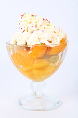 Fruit salad with whipped cream and colorful sprinkles