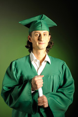 portrait of a happy succesful man on his graduation day in green