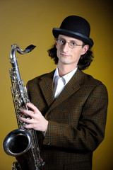 young man  in bowler hat holding saxophone
