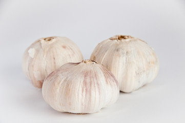 Three garlic bulbs on white background.