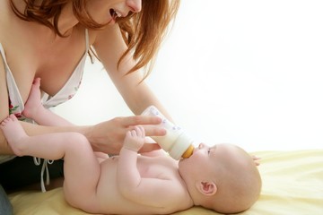 Obraz na płótnie Canvas nude blond baby playing mother hands