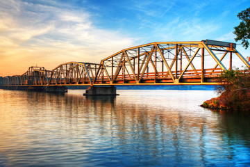Toll Bridge Over River At Sunrise