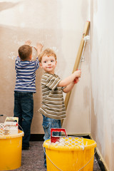 Zwei Kinder malern eine Wand daheim