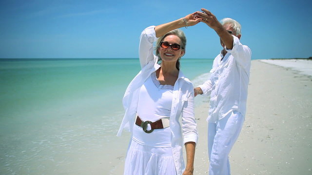 Senior couple having fun dancing on the beach