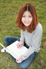 asian girl with laptop on grassland