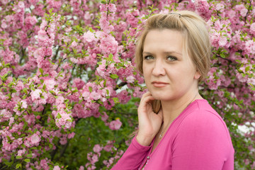 Fototapeta premium Pretty blonde young woman.Backdrop cherry blossoms.
