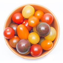 Different sorts of tomatoes served on a orange dish.