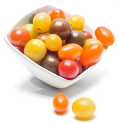 Different sorts of tomatoes served on a white dish.