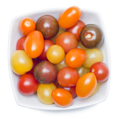 Different sorts of tomatoes served on a white dish.