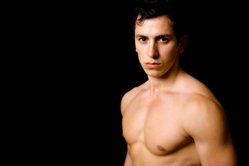 Fototapeta premium Portrait of young sensual man on a black background