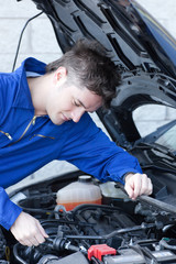 Fototapeta na wymiar Concentrated man repairing a car