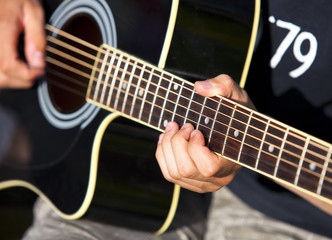 Fototapeta na wymiar playing a black accoustic guitar