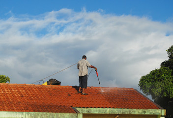 Man cleaning the roof with water jet