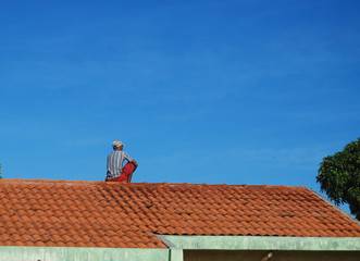 Fototapeta na wymiar Man sitting on the roof