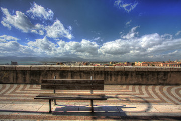Fototapeta na wymiar Bench with city view under a blue sky