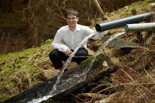 Junger Mann in Tracht beim Wasser