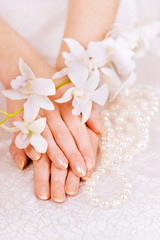 Fototapeta premium woman's hands, pearl beads and white orchid
