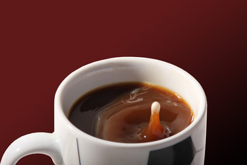 Milchtropfen in Kaffeetasse